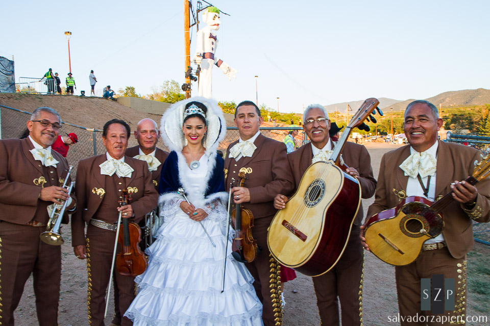 2013 Fiestas de Santa Fe Queen Kristy Ojinaga y Borrego poses with members of Mariachi Buenaventura.