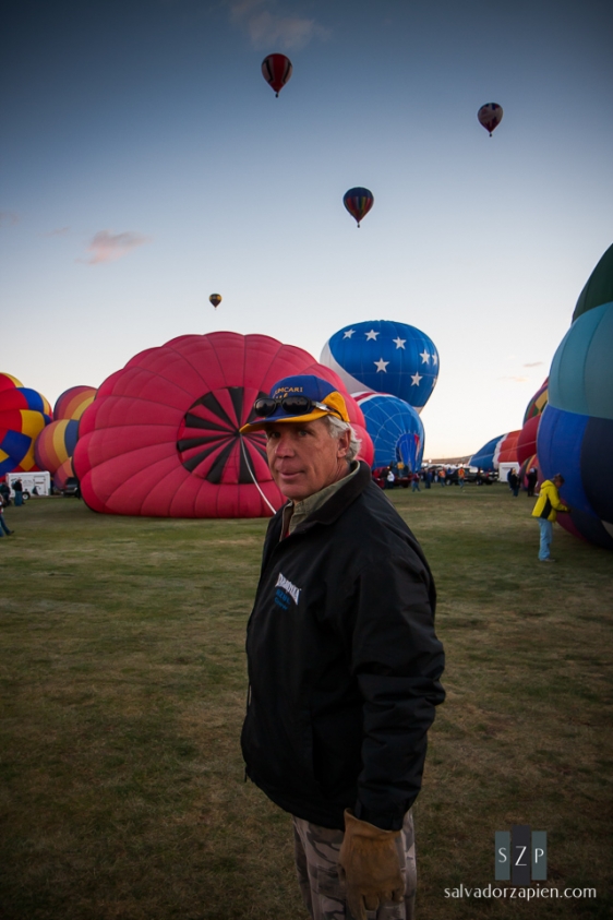 This man was pulling on the rope to get the red balloon behind him up.